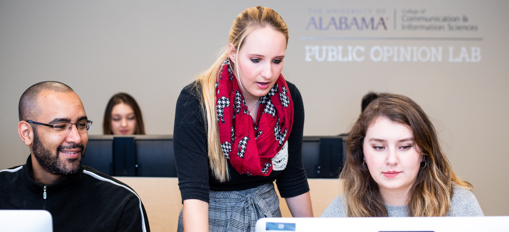 Image of research assistnat Kelsey Bruce teaching students how to use research tools in the Public Opinion Lab.